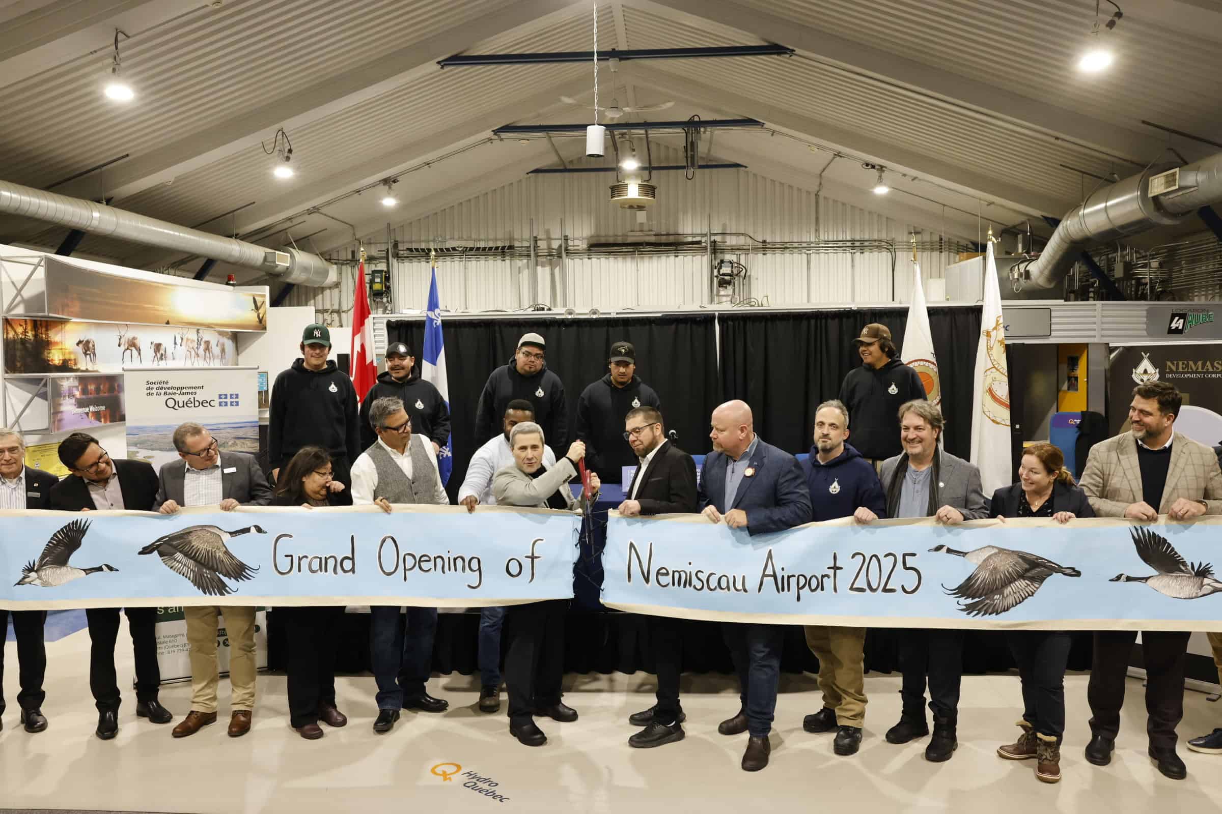 Group of people holding banner indoors.